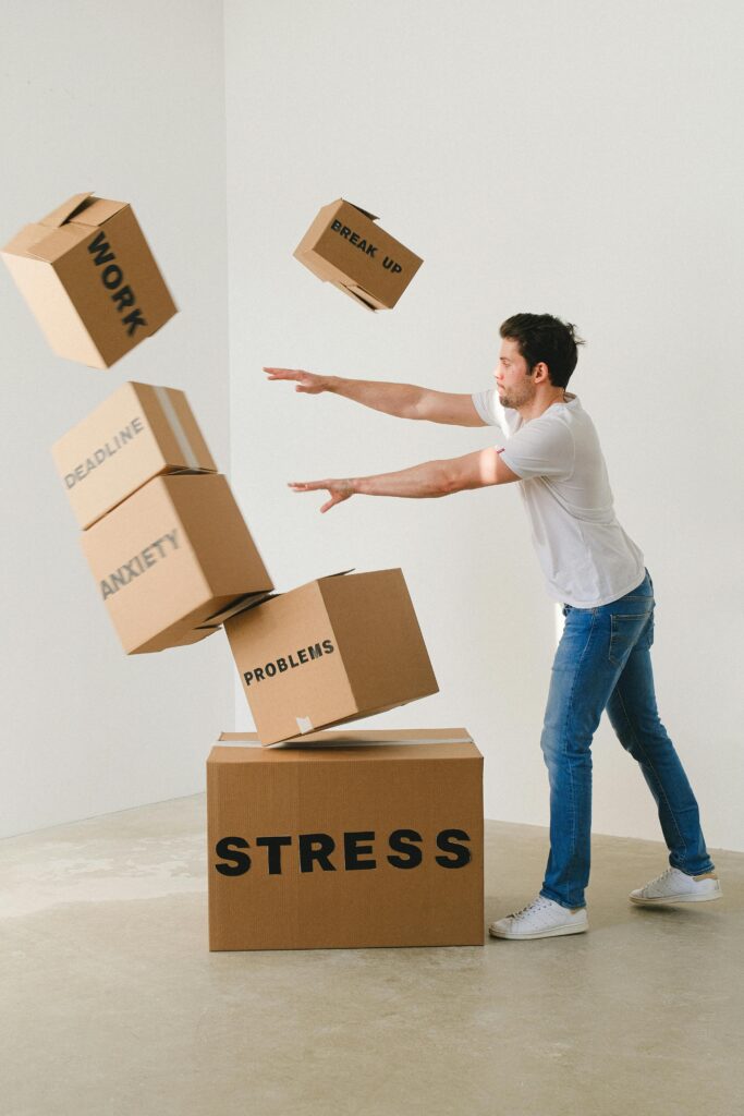 pexels-photo-7203956-7203956 Full body of young man in sneakers and jeans pushing and falling boxes saying Work Problems Anxiety Stress and Deadline while fighting with problems